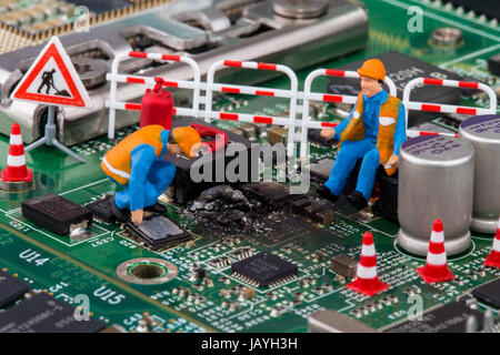 miniature workers on a computer mainboard - studio shot Stock Photo