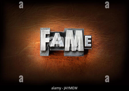 The word fame made from vintage lead letterpress type on a leather background. Stock Photo