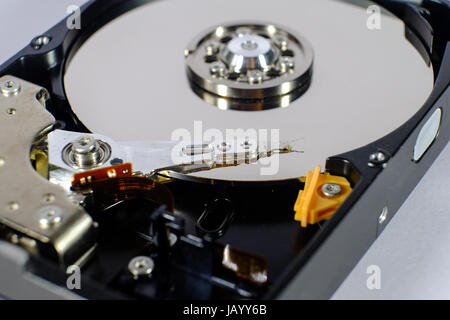 opened hard disk drive shows the disc and the read and write head. focus on the read and write head Stock Photo