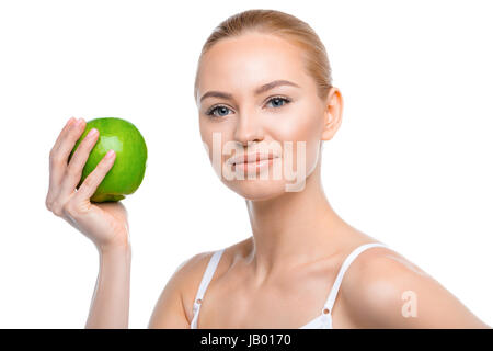 Beautiful young woman holding green apple and smiling at camera Stock Photo