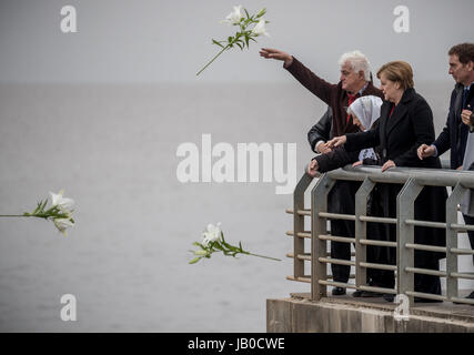 Buenos Aires, Argentina. 8th June, 2017. German chancellor Angela Merkel visits the Parque de la Memoria (Park of remembrance), throwing lilies next to the mother of a missing person, Vera Jarach as well as Marcello Brodsky (L) and mayor of the city Djego Santilli (R) at the Rio de la Plata in Buenos Aires, Argentina, 8 June 2017. During the military dictatorship numerous Argentinian political opponents disappeared without a trace. Merkel is residing in Argentina in preperation for the G20 summit. Photo: Michael Kappeler/dpa/Alamy Live News Stock Photo