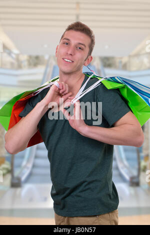 Ein junger Mann beim Shoppen mit Einkaufstaschen in einer Shopping Mall