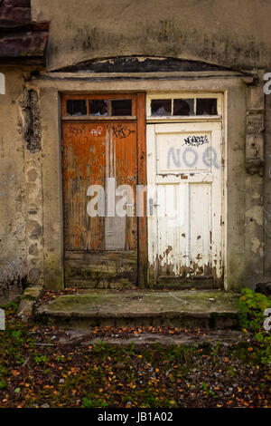Two doors on an old abandoned building in the area of Nomme in Tallinn, Estonia. They look like a bride and a groom in a strange wedding photo. Stock Photo