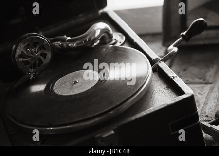 Vintage black portable wind-up gramophone, closeup black and white photo