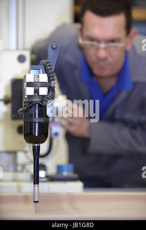 worker using a multisensor touch probe to inspect measurements Stock Photo