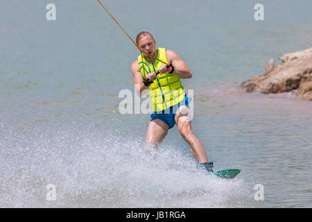 Man study wakeboarding on blue lake summer sports Stock Photo