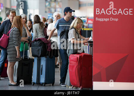 Passengers people waiting in line to check baggage at ticket counter Logan International Airport, Boston, Massachusetts Stock Photo