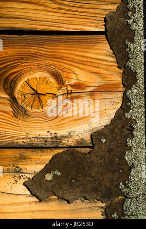 Roofing used for siding is almost all worn off on the side of this old house Stock Photo