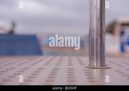 Metal Umbrella Pole On An Outdoor Poolside Table Stock Photo