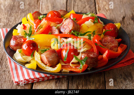 Pasta fettuccine with bell pepper and sausages close-up on a plate. Horizontal Stock Photo