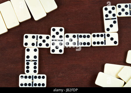 line of play in domino game on wooden table Stock Photo