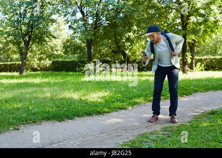 Walking in Park with Smartphone Stock Photo