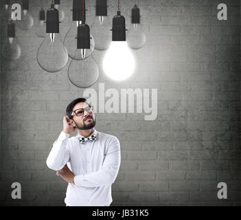 Thoughtful businessman looking at light bulb Stock Photo