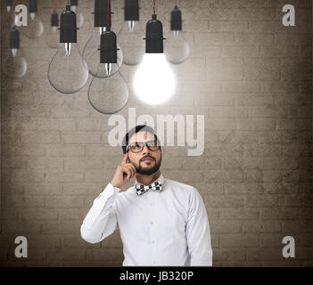 Thoughtful businessman looking at light bulb Stock Photo