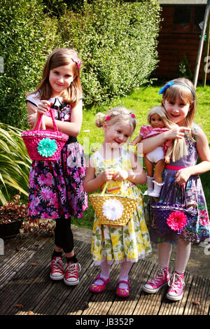 Three sisters delighted with their baskets of chocolate Easter eggs on Easter Sunday Stock Photo
