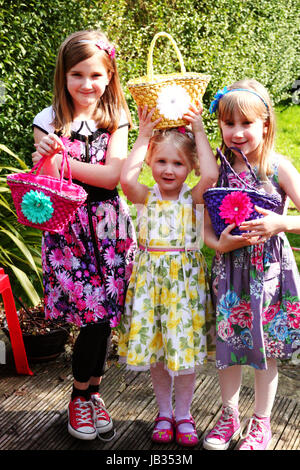 Three sisters delighted with their baskets of chocolate Easter eggs on Easter Sunday Stock Photo