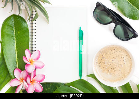 Tropic flat lay top view tropical botanical summer concept with note book sunglasses coffee cup pineapple palm leaves and plumeria on white Stock Photo