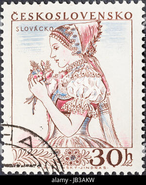 CZECHOSLOVAKIA- CIRCA 1956: A postage stamp printed in the Czechoslovakia shows portrait of young woman in Slovakian national costume, circa 1956
