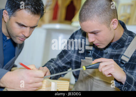 two designers working together in workshop with precision tools Stock Photo