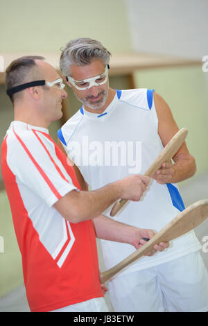 2 men chatting between two pelota games Stock Photo