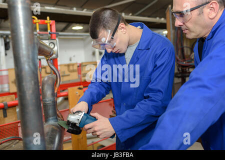 male trainee plumber working on central heating boiler Stock Photo