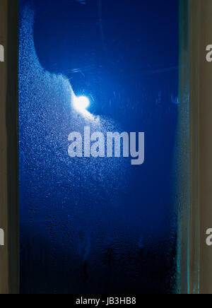 Moonlight through the window. Sweaty glass Stock Photo