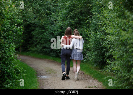 Teenage French girls sisters walking together on a wooded path, Brittany, France Stock Photo