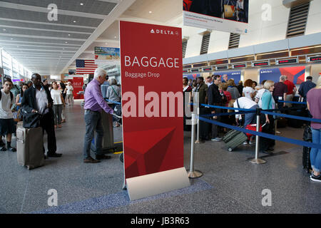 Passengers people waiting in line to check baggage at ticket counter Logan International Airport, Boston, Massachusetts Stock Photo