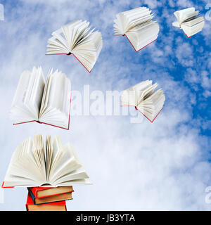 open books fly out of pile of books with cloudy blue sky background Stock Photo