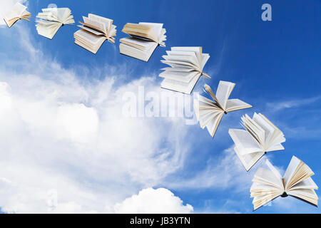 arch of flying books with blue sky and white cloud background Stock Photo