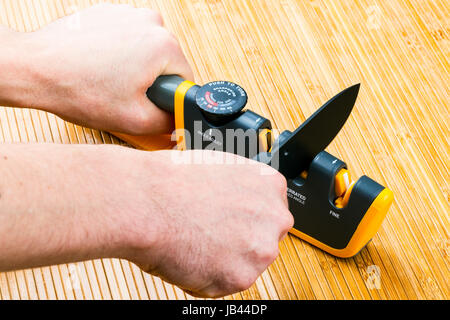 adjustable manual knife sharpener on wooden background Stock Photo