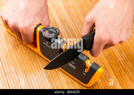 adjustable manual knife sharpener on wooden background Stock Photo