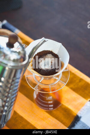 Pour Over Coffee Drip Brewing with paper filter while coffee blooming Stock Photo