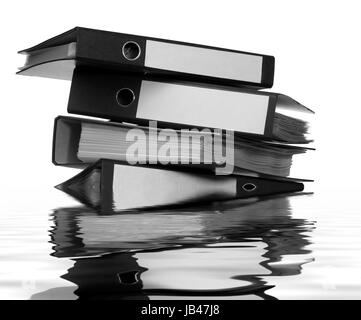 stack of partly sunken folders on reflective water surface Stock Photo