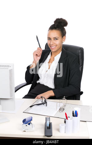 Junge, hübsche Angestellte sitzt am Schreibtisch im Büro und hält einen Stift Stock Photo