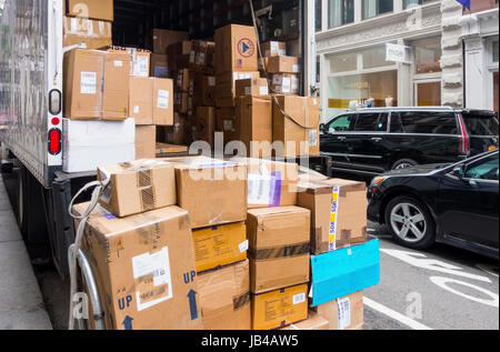 FedEx truck delivering boxes on a busy crowded street in New York City Stock Photo