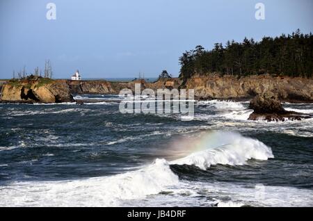 Cape Arago Lighthouse with Rainbow Wave, Coos County, Oregon Stock Photo