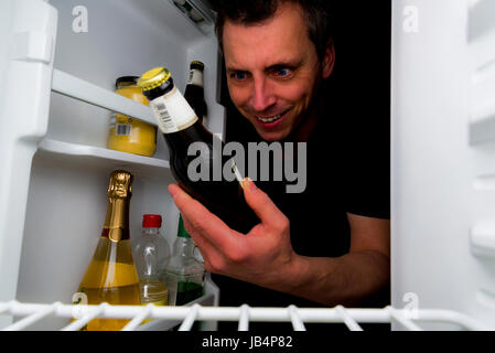 man desperately in need of a beer at night. all logo's removed. Stock Photo