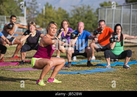 Mixed group of people doing a boot camp exercise class Stock Photo