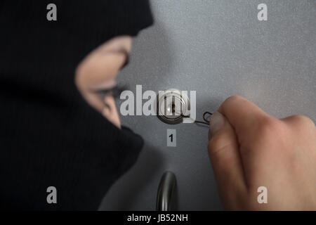 Burglar in action, trying to open the lock Stock Photo