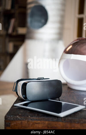 Virtual reality headset, digital tablet and helmet on table Stock Photo