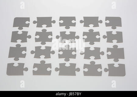 20 jigsaw puzzle pieces placed on illuminated white background. Stock Photo