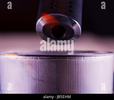 Black lighter with lit flame near a candle, close up Stock Photo