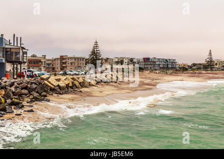 Waves, stones at the coastline with houses in background, Swakopmund German colonial town, Namibia Stock Photo