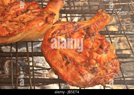 Grilled chicken thigh on the flaming grill Stock Photo