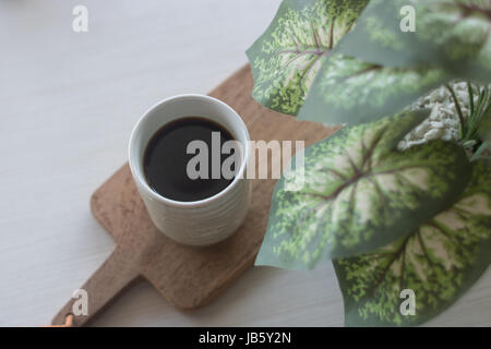 Coffee drip in ceramic vintage cup with artificial  plant Stock Photo