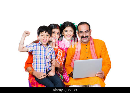Happy Indian Rural Parents And 2 Children Sitting Together And Using Laptop Successful Education Learn Stock Photo