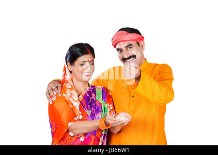 2 Indian Rural farmer Couple Holding wheat in his hand Falling Wheat Purity Quality Stock Photo