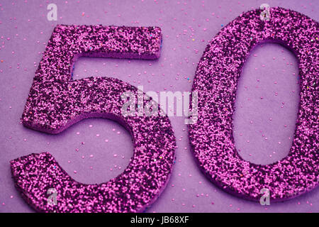 Number fifty purple color over a purple background. Anniversary. Horizontal Stock Photo