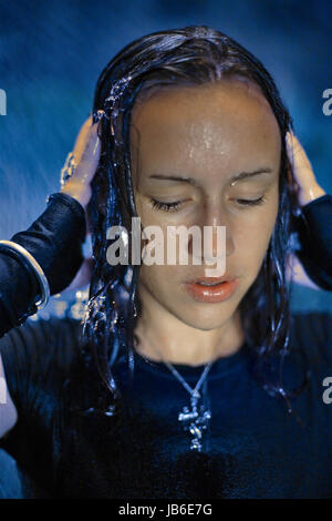 Young woman during storm at night holding head. 16, 17, 18, 19, 20, 21, 25, years, years old Stock Photo